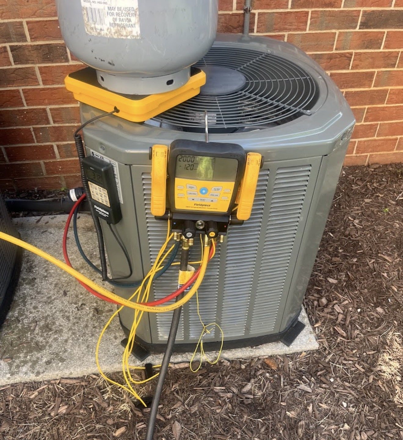 Outdoor HVAC condensing unit with gauges during service